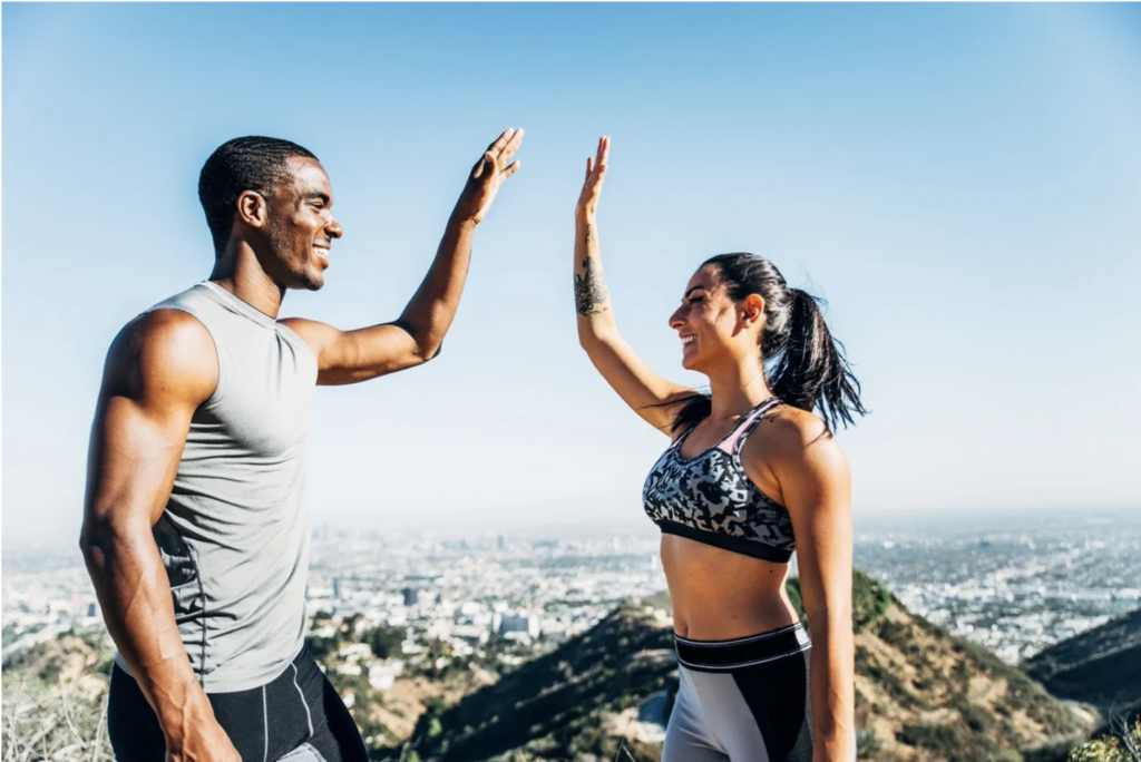 Man and women high fiving after exercising and being happy.  