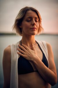 Woman with eyes closed and hand on heart. Photo by Darius Bashar on Unsplash