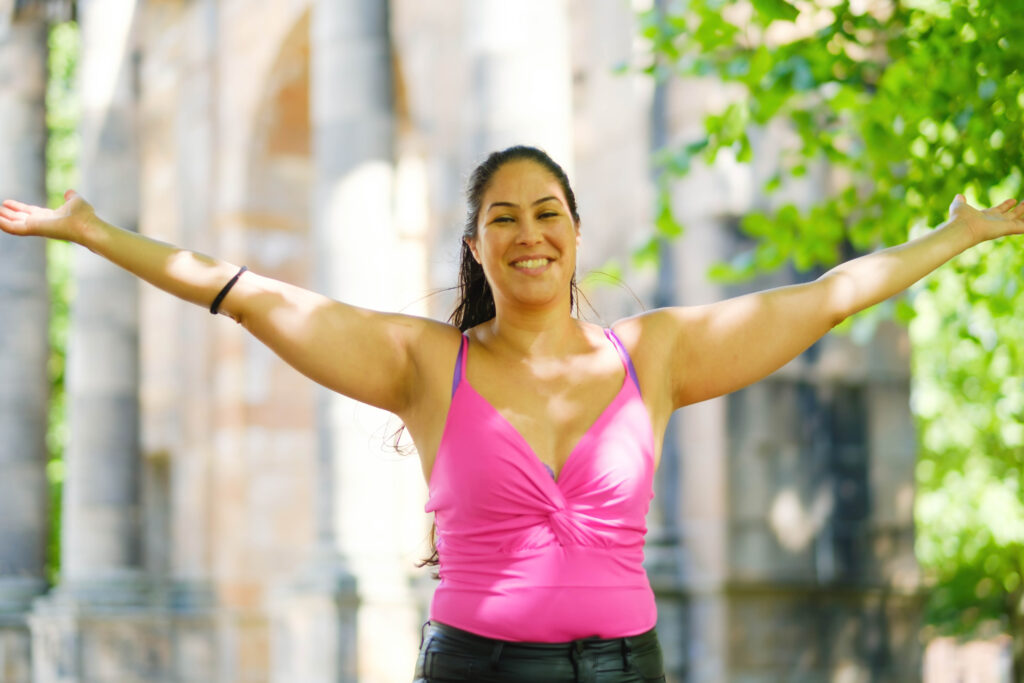 Ceza, Relationship Coach, with her arms up and wide, smiling and happy because she can be her true self. 