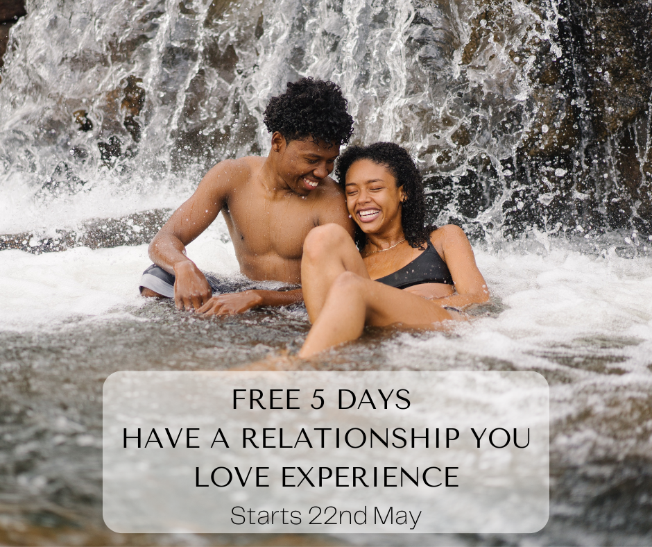 Man and woman sitting in waterfall, happy and laughing. They are in love.