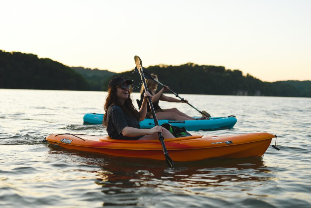 A woman and her date kayaking. They are smiling and happy. 