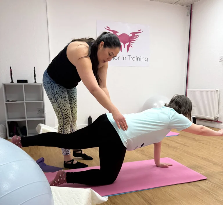 Pilates Instructor, Ceza, adjusting the position of a pregnant client during a Prenatal Pilates Class.