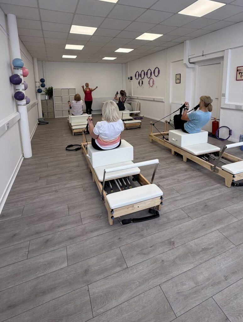 A reformer class with 4 participants and an instructor.