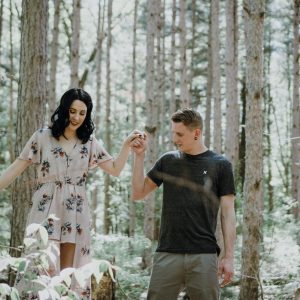 Man and woman walking through woodlands, holding hands. Photo by Amber Kipp on Unsplash